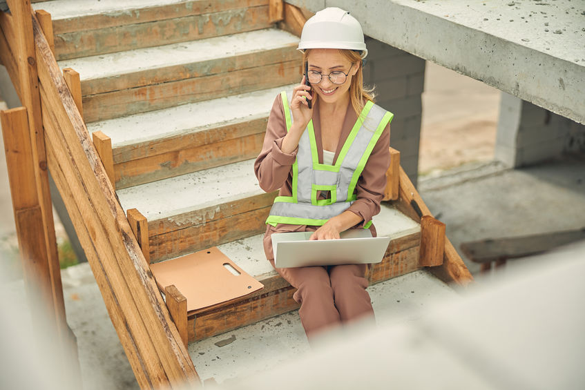 Businesswoman with a laptop sitting on the steps