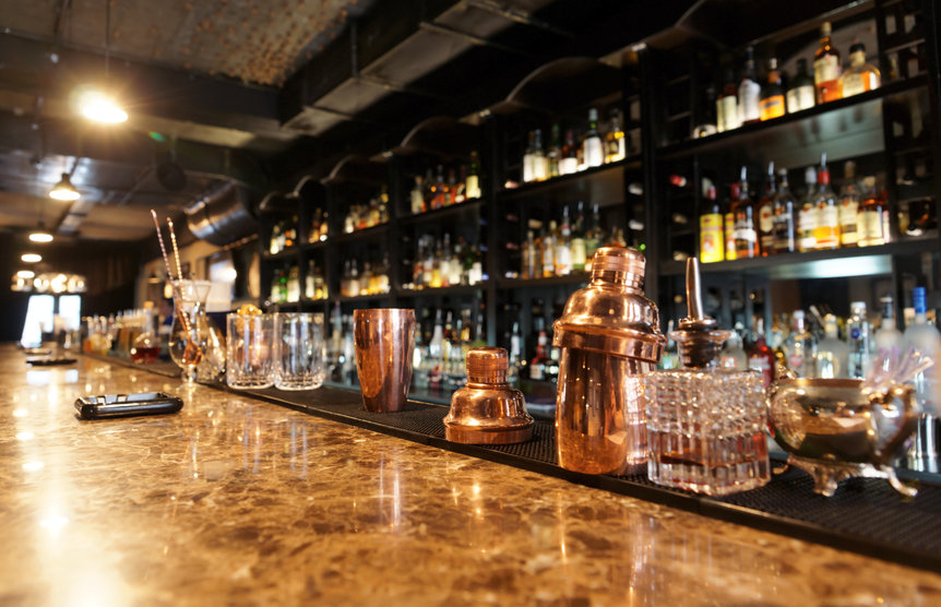 Classic bar counter with bottles in blurred background